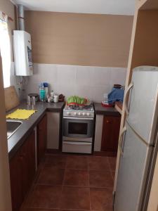 a small kitchen with a stove and a refrigerator at Cabaña tayta munay in Purmamarca +18 photos