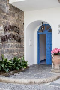 a blue door to a building with a sign on a wall at Hotel Mignon Meublè in Sorrento