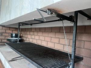 a metal grill in a room with a brick wall at Casa Ancona casa quinta in Joaquín Gorina