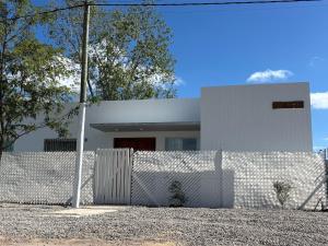 a white house with a fence in front of it at Casa Ancona casa quinta in Joaquín Gorina