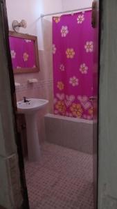 a bathroom with a sink and a shower curtain with flowers at Sol y Luna in Termas de Río Hondo