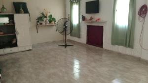 a living room with a fireplace and a fan at Sol y Luna in Termas de Río Hondo