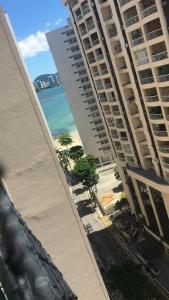a view of the beach from the balcony of a building at Pitangueiras Pé na Areia in Guarujá