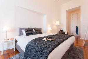 a bedroom with a large bed with a tray on it at d'Castro Luxury Apartments - Alfama in Lisbon