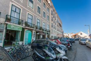 uma fila de motocicletas estacionadas ao lado de uma rua em d'Castro Luxury Apartments - Alfama em Lisboa