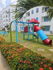 a playground in a park next to a building at Paraiso Coveñas, Unidad con la mejor piscina in Coveñas
