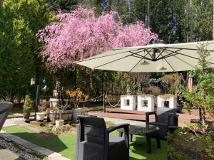 a table and chairs and an umbrella in a garden at Kakureyado Fujikawaguchiko in Fujikawaguchiko