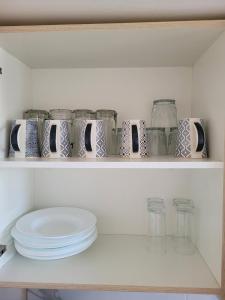 a shelf with jars and plates on it at Casa Privada El Marqués Qro in Querétaro
