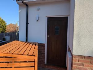 a wooden door on the side of a house at Ox Lane Annexe - Harpenden in Harpenden