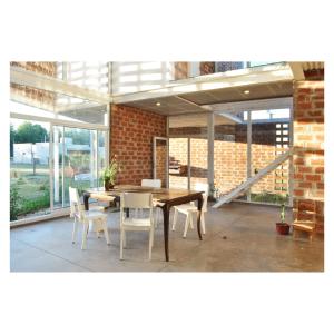 a dining room with a table and chairs and a brick wall at Casa PDS in La Porteña