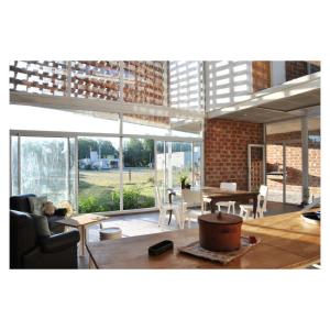 a living room with tables and chairs and windows at Casa PDS in La Porteña