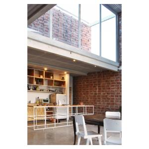a kitchen with a table and chairs and a brick wall at Casa PDS in La Porteña