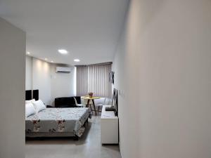 a bedroom with a bed and a table in a room at Flat em Intermares in Cabedelo
