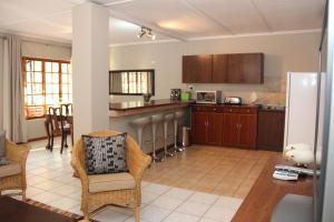 a kitchen with a table and chairs and a refrigerator at Augrabies Valle Guesthouse in Augrabies