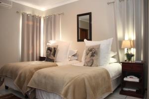 a bedroom with two beds and a mirror at Augrabies Valle Guesthouse in Augrabies