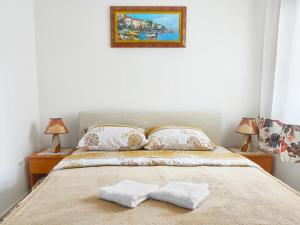 a bedroom with a bed with two towels on it at Blue Mare Apartment in Petrovac na Moru