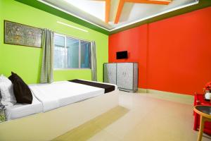 a bedroom with red and green walls and a bed at Hotel O Shiv Shakti Homestay in Jalpāiguri +22 photos