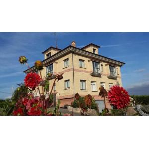 una casa grande con flores delante en Alojamientos Mirapeñas, en El Campo