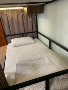 two twin beds in a small room withthritisthritisthritisthritisthritisthritisthritisthritis at 隔壁棟 in Hsinchu City