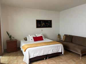 une chambre avec un grand lit et un canapé dans l'établissement Casa El Pinar, à Jardín