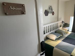 a bedroom with a bed with a sign on the wall at Pimpompul Vakantiewoning in Oudenaarde