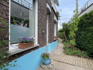 a window with pots of flowers on the side of a house at Pimpompul Vakantiewoning in Oudenaarde