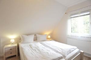 a bedroom with a bed with white sheets and a window at Haushaelfte-Hein-105 in Böhl