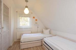 a bedroom with two beds and a window at Haushaelfte-Hein-105 in Böhl
