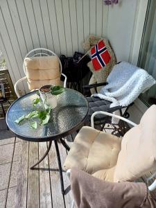 a table and chairs on a porch with a flag on it at Sentrums nærsentrum tur og sjø på hundvåg in Lii