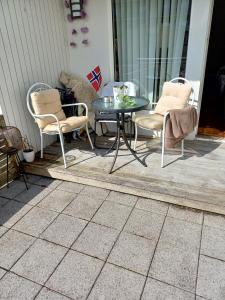 a patio with two chairs and a table on a porch at Sentrums nærsentrum tur og sjø på hundvåg in Lii