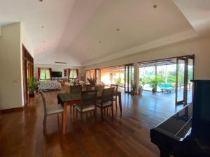 a dining room and living room with a table and chairs at Exclusive 10-Person Villa with Pool & land 6000m in Ban Hui Yai Muk