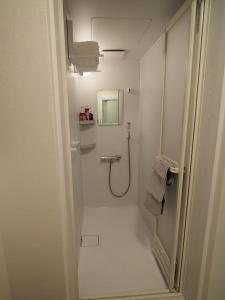 bagno bianco con doccia e specchio di 映画館みたいなお部屋で非日常体験 キッチン付きで家族も安心 1日1組限定貸切ステイ シンカイハウス a Izu
