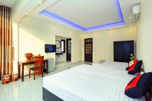 a bedroom with a large white bed and a desk at Royal Homestay in Hoi An