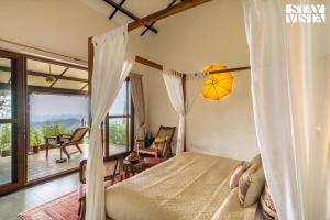 ウーティにあるUnder the Stars Luxury Stay at Lovedale ootyのベッドとバルコニーのある寝室