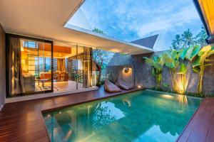 an indoor pool in a house with a large window at Villa Padi - Breathtaking Design with Pool & Ricefield Views in Ubud