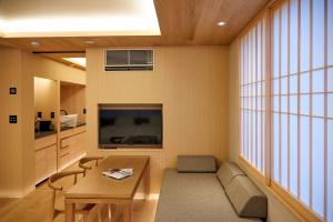 a living room with a table and a large window at MKG HOTEL Asakusa in Tokyo
