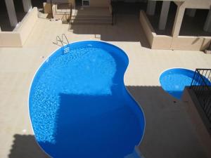 a large blue pool with a letter carved into it at Melania Apartment in Paphos City