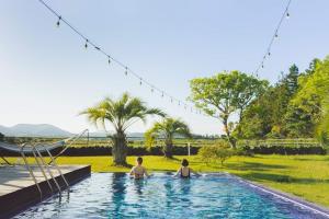 two people sitting in a swimming pool at AroundFollie in Seogwipo