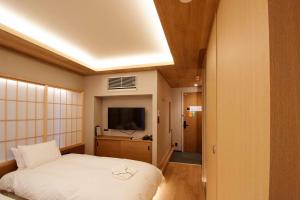 a bedroom with a white bed and a television at MKG HOTEL Asakusa in Tokyo +118 photos