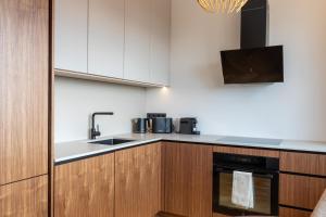 a kitchen with a sink and a stove top oven at Heven Apartments Karusselli in Pärnu