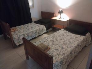 una camera con tre letti, un tavolo e una lampada di Mate host 2 a Córdoba