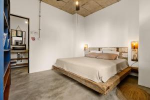 ein Schlafzimmer mit einem Bett mit Holzrahmen in der Unterkunft Yesterday in Petit Brûlé