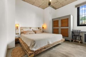 ein Schlafzimmer mit einem großen Bett mit Holzrahmen in der Unterkunft Yesterday in Petit Brûlé