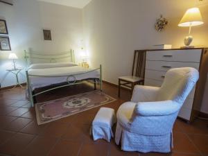 a bedroom with a bed and two chairs and a dresser at Casa Flora in Spello