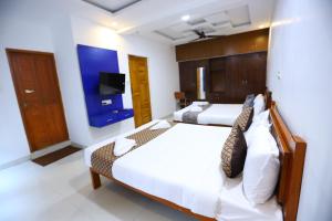 钦奈Hotel Starlight Chennai near DLF,L&T,Miot,Tradecenter,Ramachandra medical coll的一间卧室，配有两张床和一台平板电视