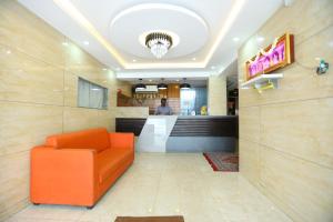 a lobby with an orange chair and a bar at Hotel Starlight Chennai near DLF,L&T,Miot,Tradecenter,Ramachandra medical coll in Chennai