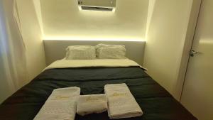 a small bed with two white towels on it at Studio com vista espetacular! in Niterói