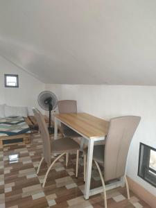 a dining room with a wooden table and chairs at G-Bay Farm Village in Malolos