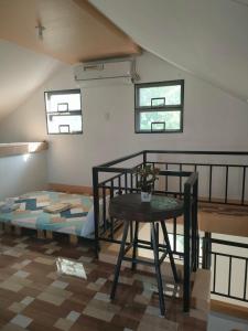 a room with a bed and a table and windows at G-Bay Farm Village in Malolos