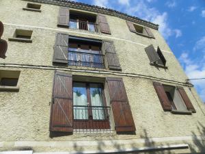 a building with wooden doors and windows on it at Provencal Vintage Cocoon in LʼIsle-sur-la-Sorgue